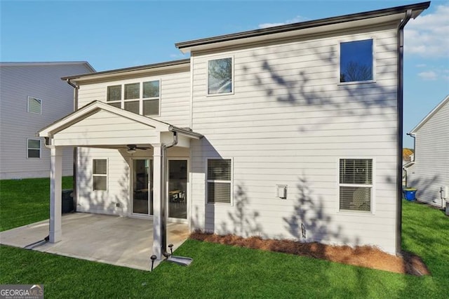 rear view of property featuring ceiling fan, a yard, and a patio area