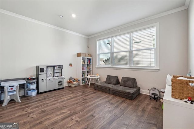 sitting room with dark wood-type flooring and crown molding