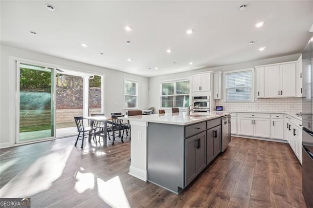 kitchen with white cabinetry, a wealth of natural light, and dark hardwood / wood-style floors