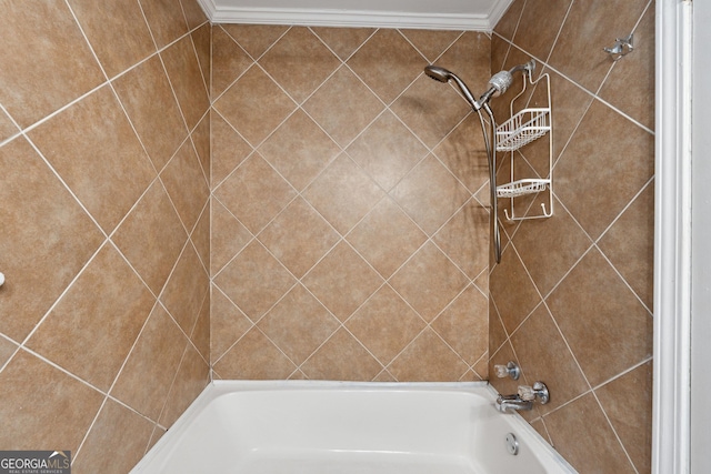 bathroom featuring crown molding and tiled shower / bath