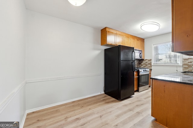 kitchen with tasteful backsplash, black appliances, and light hardwood / wood-style floors