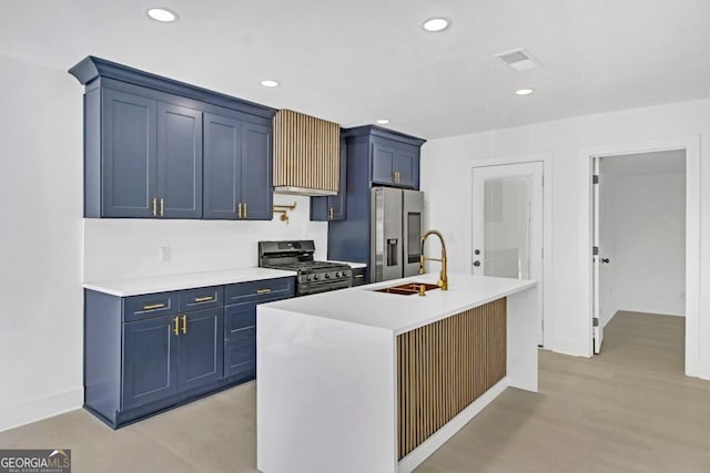 kitchen with appliances with stainless steel finishes, light countertops, a sink, and blue cabinetry