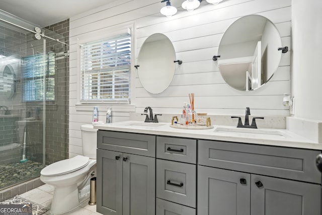 bathroom with tile patterned flooring, toilet, wooden walls, a shower with door, and vanity