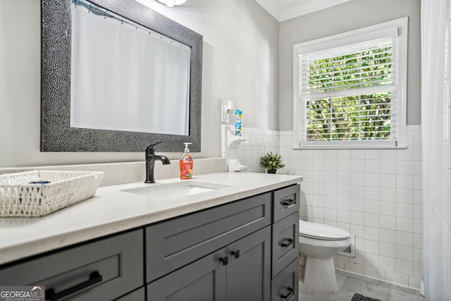 bathroom featuring vanity, toilet, crown molding, and tile walls