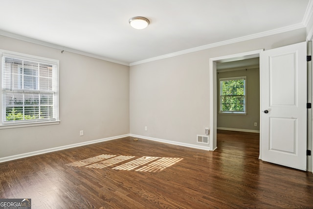 empty room with crown molding, dark hardwood / wood-style flooring, and a healthy amount of sunlight