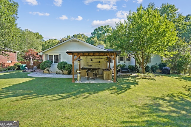 rear view of property with ceiling fan, a patio area, and a yard