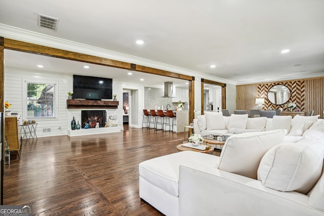 living room with a fireplace, dark hardwood / wood-style flooring, and crown molding