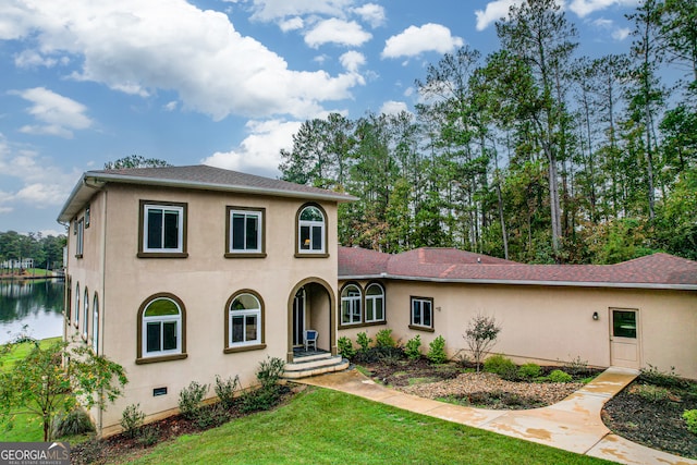 view of front of house with a front yard and a water view