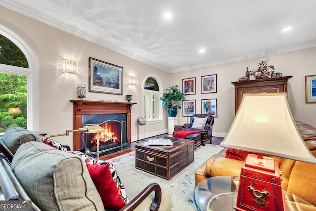 living room with ornamental molding, a wealth of natural light, light hardwood / wood-style flooring, and a high end fireplace