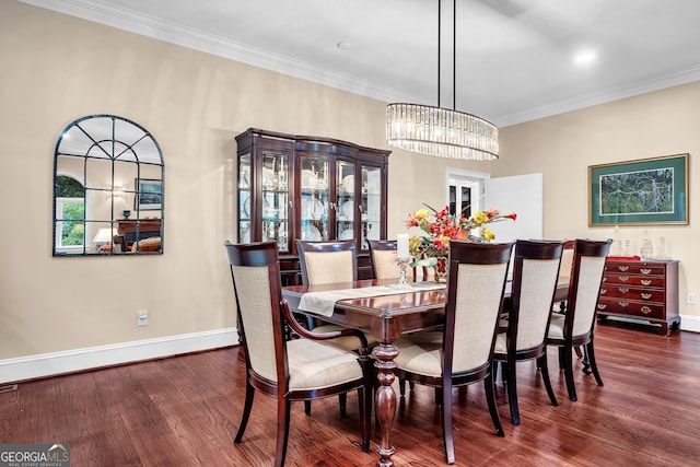 dining area featuring dark hardwood / wood-style floors, an inviting chandelier, and ornamental molding