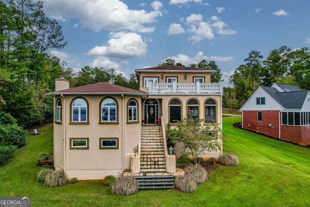 view of front of house with a front yard and a balcony