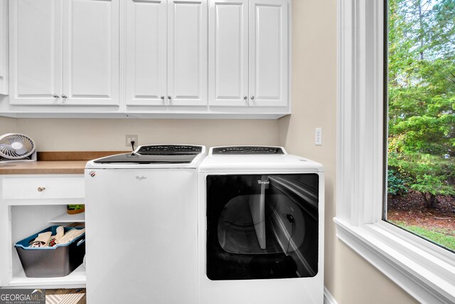 washroom featuring cabinets, independent washer and dryer, and a healthy amount of sunlight