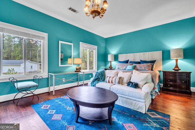 bedroom featuring a chandelier, wood-type flooring, and crown molding