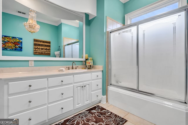 bathroom with an inviting chandelier, tile patterned floors, combined bath / shower with glass door, vanity, and ornamental molding