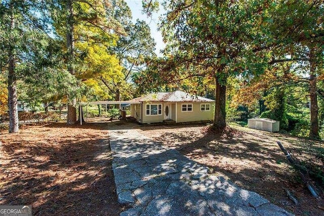 view of front of house with a carport and a storage shed