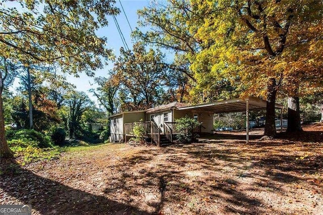 view of side of property with a wooden deck and a carport