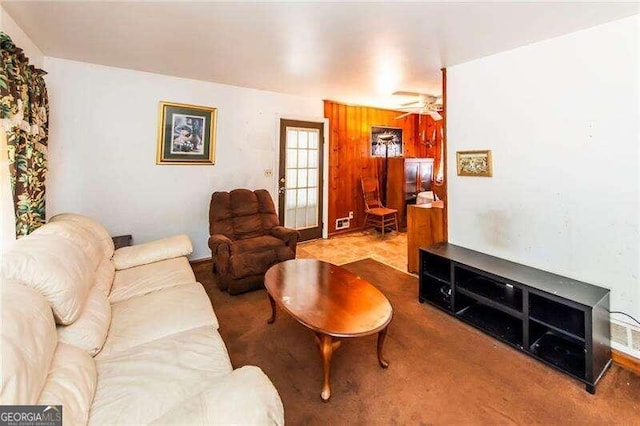 living room with wooden walls and ceiling fan