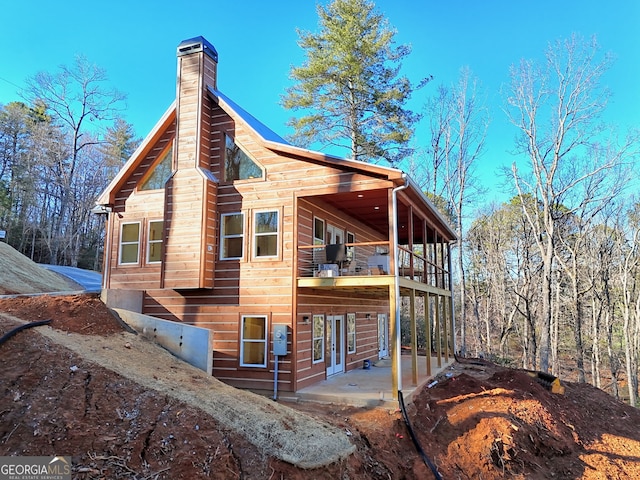 view of home's exterior with a patio and a balcony