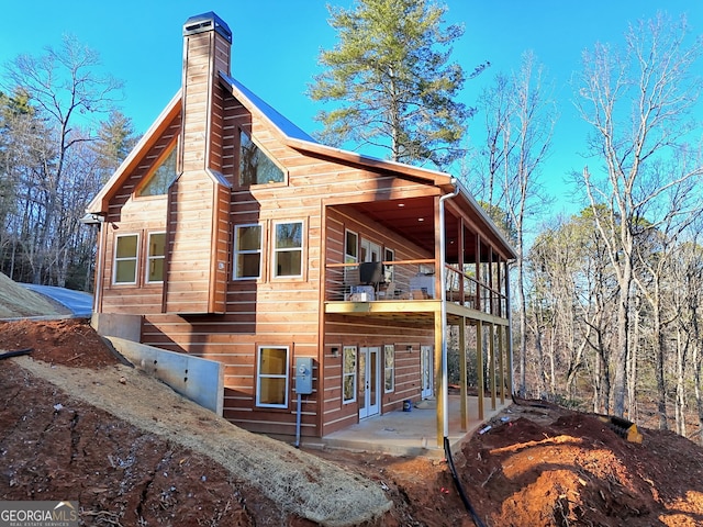 view of side of home with a patio and a balcony