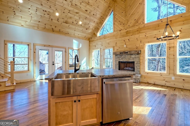 kitchen featuring sink, pendant lighting, dishwasher, french doors, and a kitchen island with sink