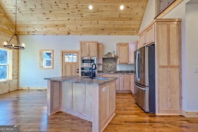 kitchen featuring appliances with stainless steel finishes, light brown cabinetry, and a kitchen island with sink