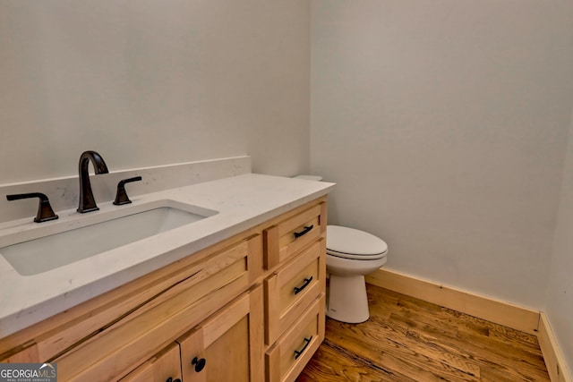 bathroom featuring toilet, wood-type flooring, and vanity