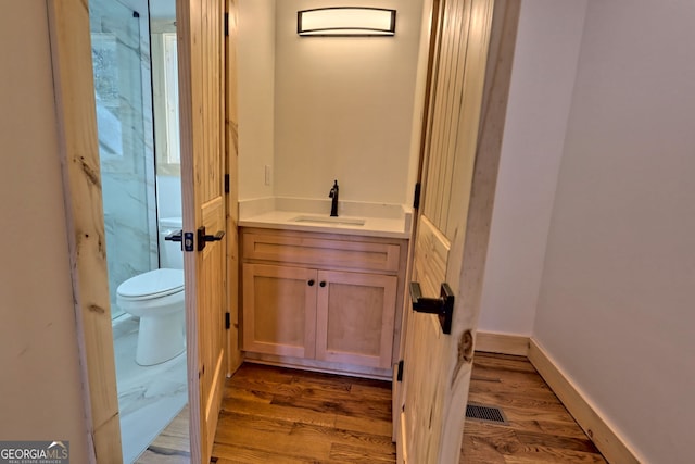 bathroom featuring vanity, toilet, and hardwood / wood-style floors