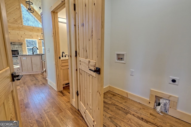 corridor featuring sink and light hardwood / wood-style floors