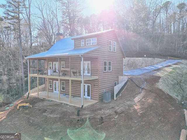 rear view of property with central air condition unit, a patio area, and french doors