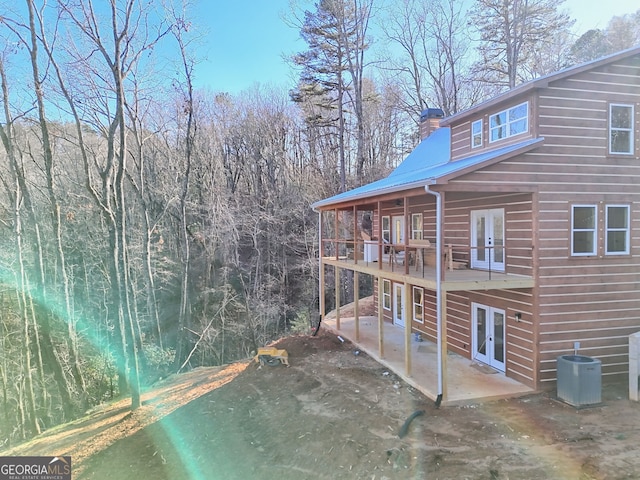 view of yard featuring french doors, central AC unit, and a patio