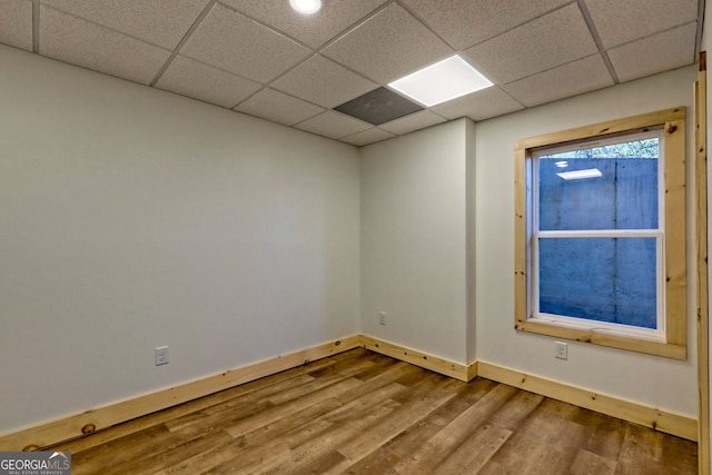 empty room featuring hardwood / wood-style flooring and a drop ceiling