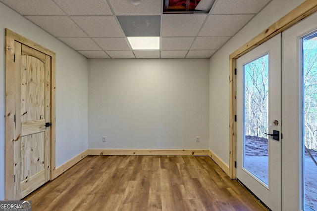 interior space featuring a paneled ceiling, french doors, and hardwood / wood-style floors