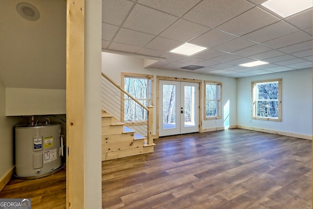 interior space featuring a paneled ceiling, french doors, dark wood-type flooring, and water heater