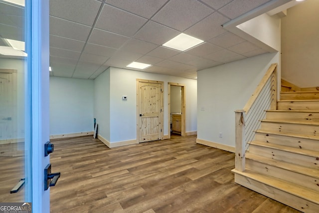 basement featuring wood-type flooring and a paneled ceiling