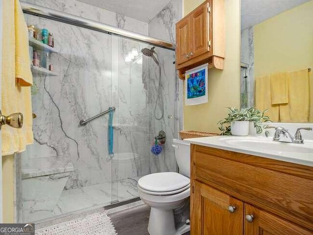 bathroom featuring vanity, toilet, and an enclosed shower