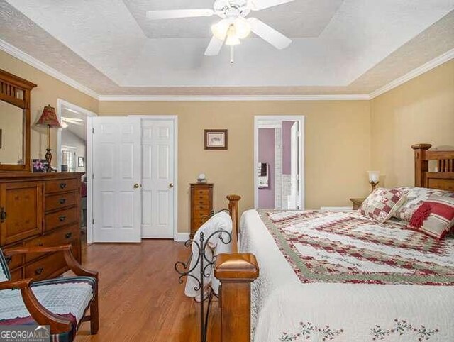 bedroom featuring ceiling fan, ornamental molding, a textured ceiling, and hardwood / wood-style flooring