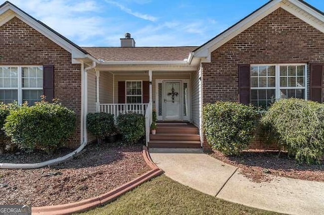 view of exterior entry with covered porch