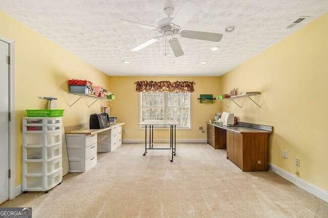 carpeted office with ceiling fan and a textured ceiling