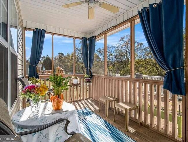 sunroom / solarium with a wealth of natural light, ceiling fan, and wood ceiling