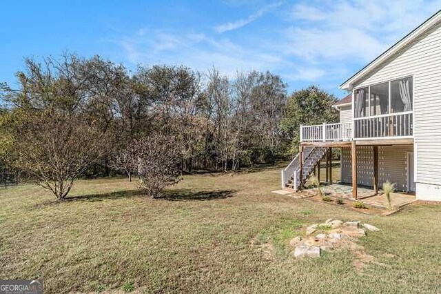 view of yard with a wooden deck and a sunroom