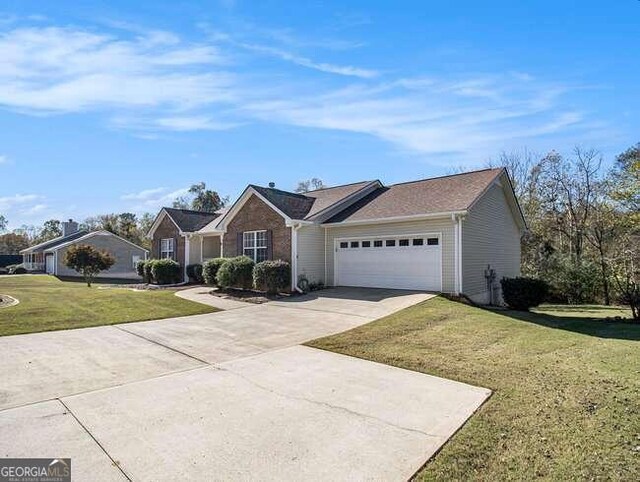 single story home featuring a garage and a front yard