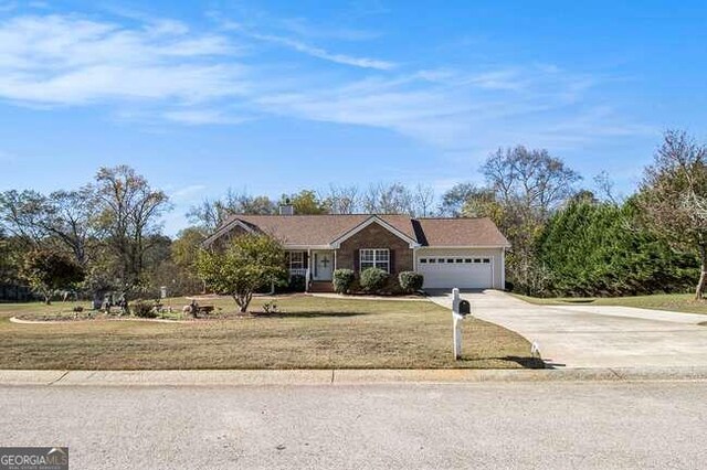 single story home with a front yard and a garage