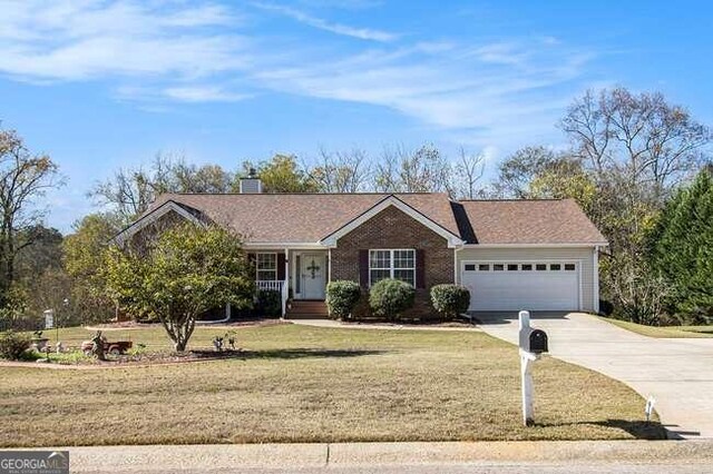 ranch-style home featuring a garage and a front yard