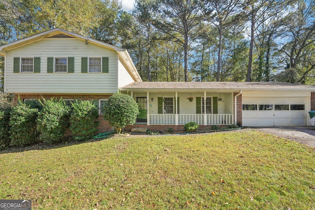 view of front of house featuring a front yard, a porch, and a garage