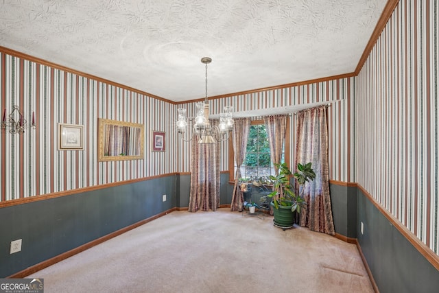 spare room featuring ornamental molding, a chandelier, carpet floors, and a textured ceiling