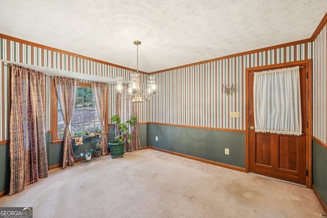 unfurnished dining area with crown molding, carpet floors, a chandelier, and a textured ceiling