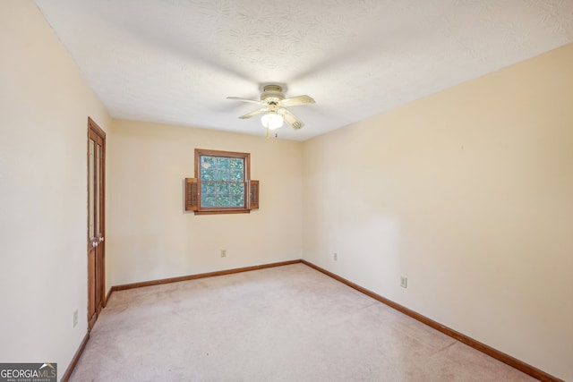 carpeted empty room with ceiling fan and a textured ceiling