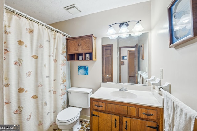 bathroom with tile patterned floors, vanity, a textured ceiling, and toilet