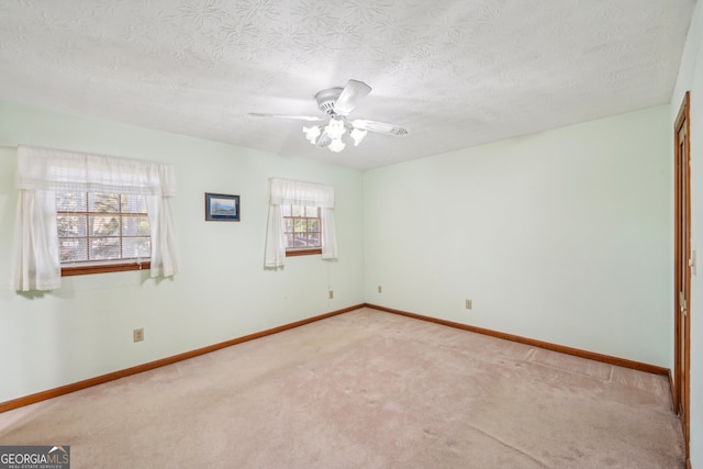 carpeted spare room featuring a textured ceiling and ceiling fan