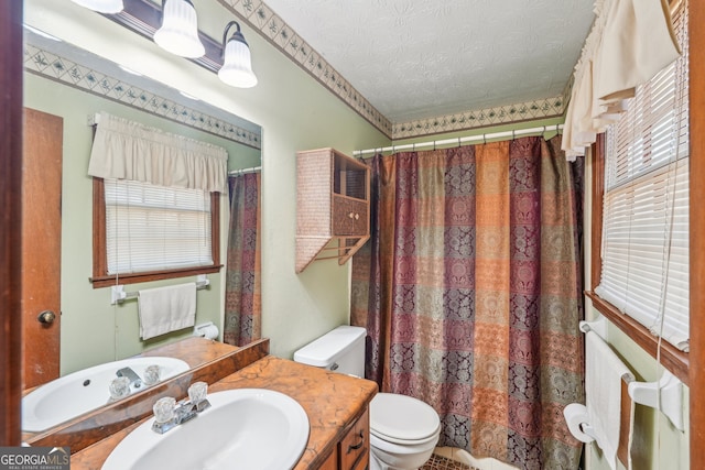 bathroom featuring vanity, a textured ceiling, and toilet